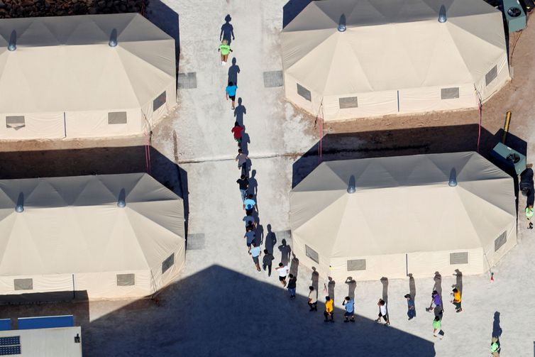 Immigrant children, many of whom have been separated from their parents under a new "zero tolerance" policy by the Trump administration, walk in single file between tents in their compound next to the Mexican border in Tornillo, Texas, U.S. June